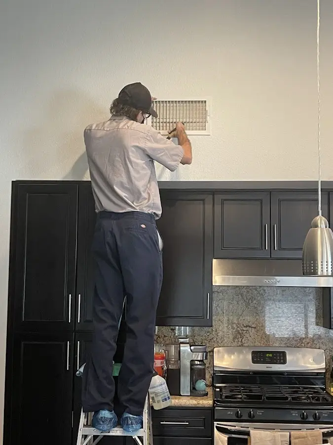 Technician inspecting an air vent during HVAC service in Wisconsin Rapids
